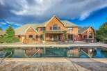 Experience luxury outdoor living with this stunning backyard featuring a sparkling swimming pool and a relaxing hot tub.