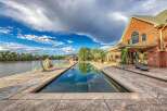 Experience luxurious waterfront living with this stunning property featuring a rectangular swimming pool overlooking a serene lake.