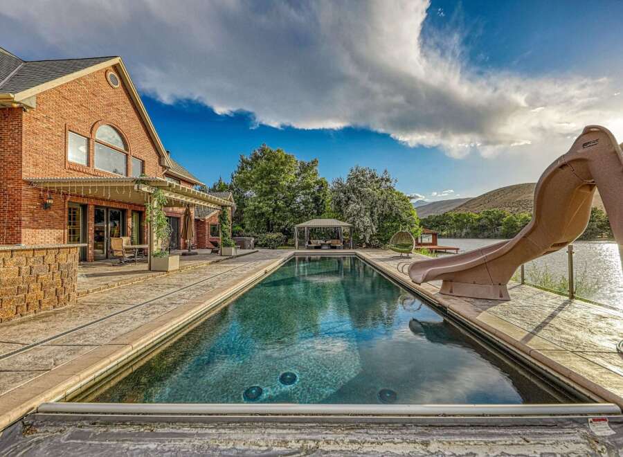 Experience luxury outdoor living with this stunning property featuring a large, rectangular swimming pool and an attached slide for endless fun.