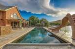 Experience luxury outdoor living with this stunning property featuring a large, rectangular swimming pool and an attached slide for endless fun.