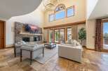 Experience luxurious living in this stunning great room featuring a floor-to-ceiling stone fireplace and a soaring vaulted ceiling.