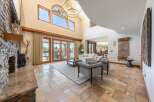 Experience luxurious living in this grand great room, featuring a stunning floor-to-ceiling stone fireplace and expansive windows that flood the space with natural light.