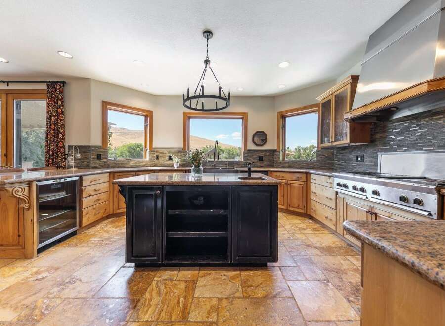 Experience luxury in this spacious kitchen featuring a large central island with a dark finish, perfect for meal preparation and casual dining.