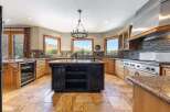 Experience luxury in this spacious kitchen featuring a large central island with a dark finish, perfect for meal preparation and casual dining.