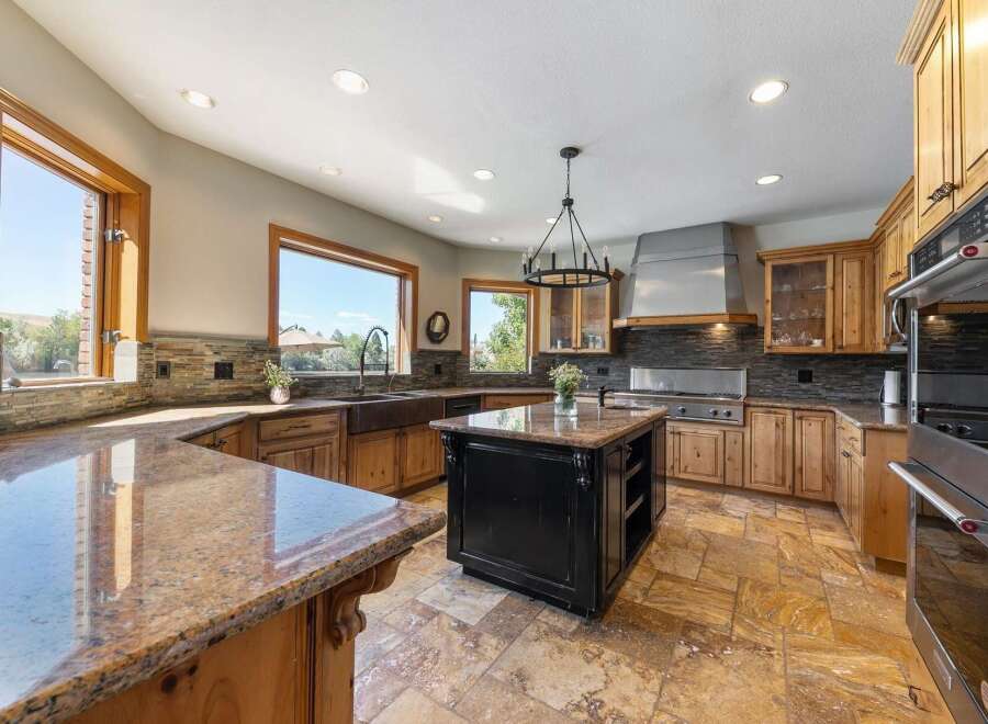 Experience luxury in this expansive gourmet kitchen, featuring custom wood cabinetry, granite countertops, and a large central island perfect for entertaining.