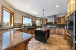 Experience luxury in this expansive gourmet kitchen, featuring custom wood cabinetry, granite countertops, and a large central island perfect for entertaining.