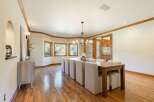 This elegant dining room features a large wooden table with upholstered chairs, perfect for hosting gatherings.