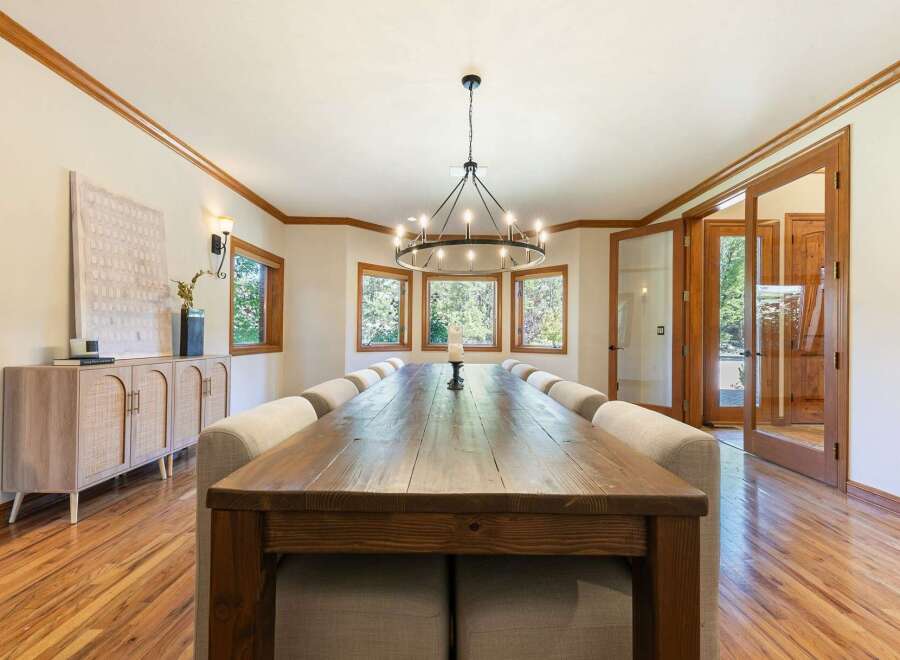 Experience elegant dining in this spacious room, featuring a long, rustic wooden table perfect for gatherings.