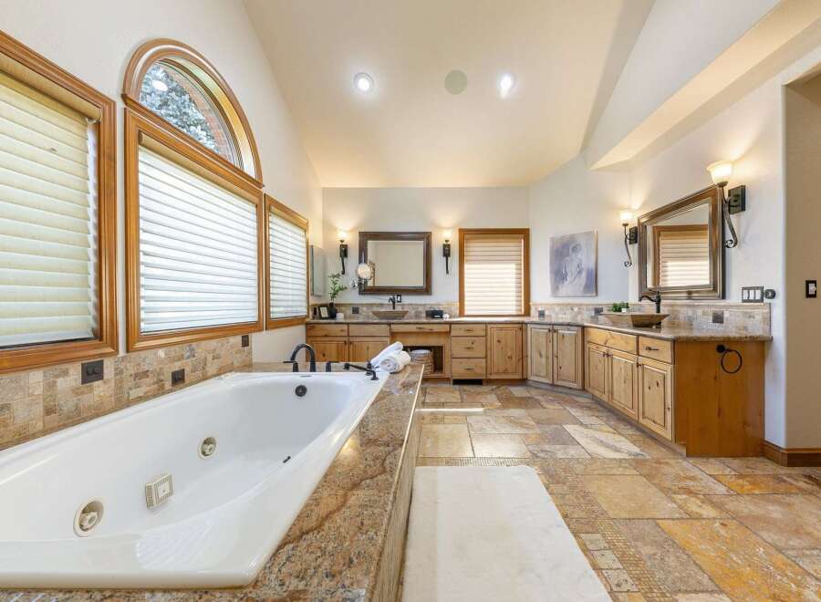 Indulge in luxury in this spacious master bathroom, featuring a deep soaking tub and dual vanities.