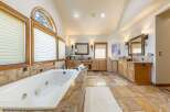Indulge in luxury in this spacious master bathroom, featuring a deep soaking tub and dual vanities.