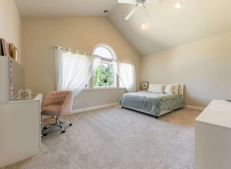 Discover this charming bedroom featuring a comfortable bed with a light green checkered comforter, perfect for a restful night's sleep.