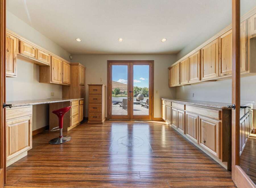 Discover ample storage and workspace in this home featuring extensive custom cabinetry and built-in desks.