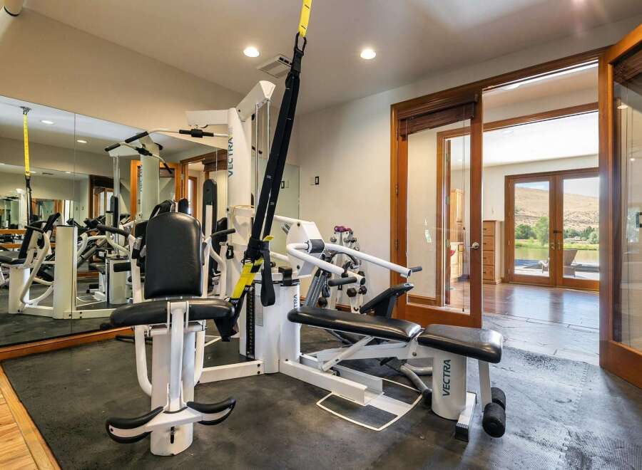 Elevate your fitness routine in this dedicated home gym, featuring a comprehensive Vectra multi-gym and TRX suspension training system.