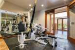 Elevate your fitness routine in this dedicated home gym, featuring a comprehensive Vectra multi-gym and TRX suspension training system.