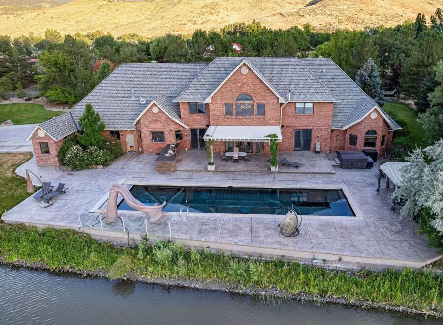 Experience luxury living with this stunning brick estate featuring a large swimming pool and a relaxing hot tub, perfect for entertaining guests.