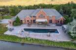 Experience luxury living with this stunning brick estate featuring a large swimming pool and a relaxing hot tub, perfect for entertaining guests.