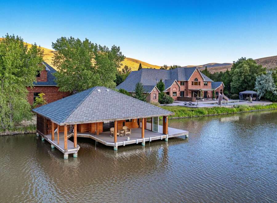 Experience luxury living with this stunning waterfront estate featuring a boathouse and a magnificent brick mansion.