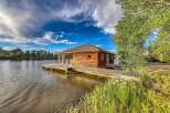 Experience unique waterfront living in this charming wooden boathouse, perfectly situated on the water's edge.