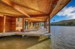 Experience waterfront living at its finest with this stunning property featuring a spacious wooden deck extending over the water.