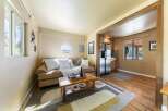 Cozy living space featuring a comfortable sofa, a rustic coffee table, and a functional kitchen area with stainless steel appliances.