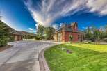 Discover this stunning brick home featuring a spacious driveway leading to a multi-car garage.