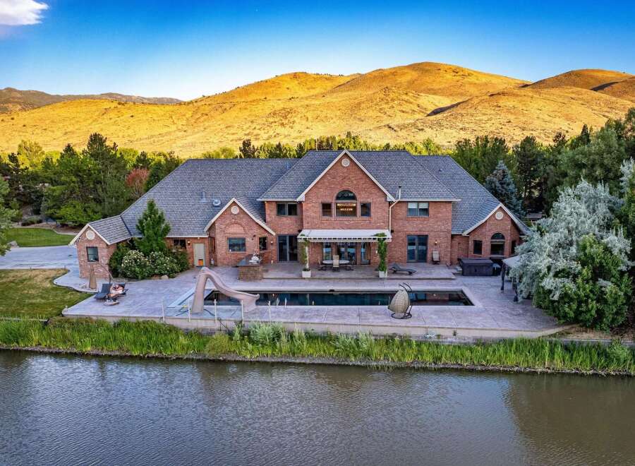 Experience luxury living with this stunning brick estate, featuring a sprawling backyard oasis complete with a large swimming pool, waterslide, and hot tub.