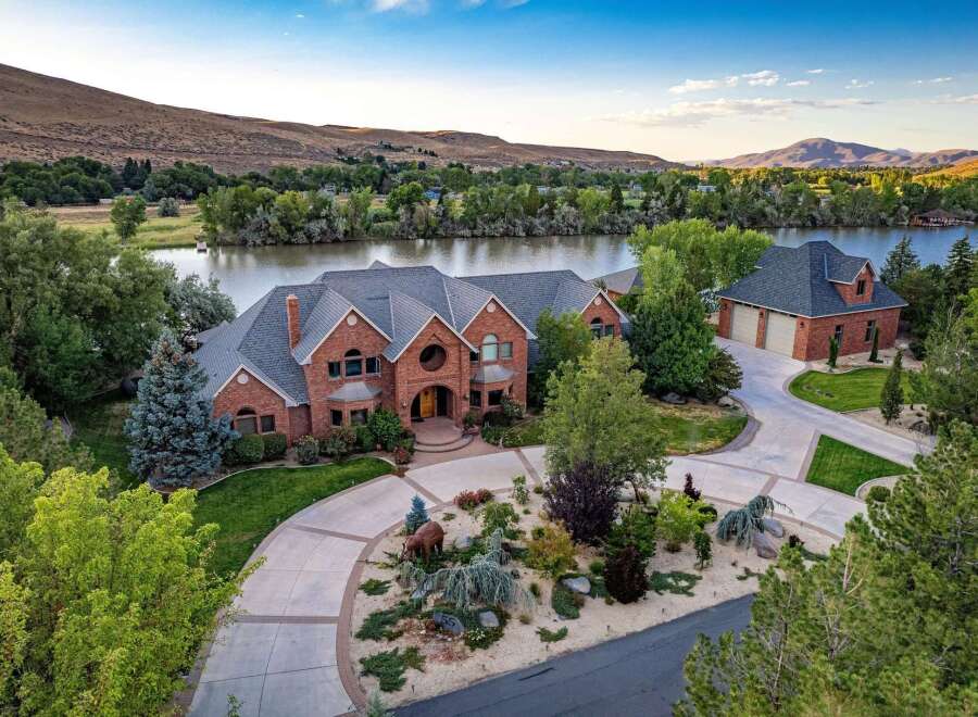 Experience luxury living with this stunning brick estate nestled beside a serene river, offering breathtaking views and ample space.