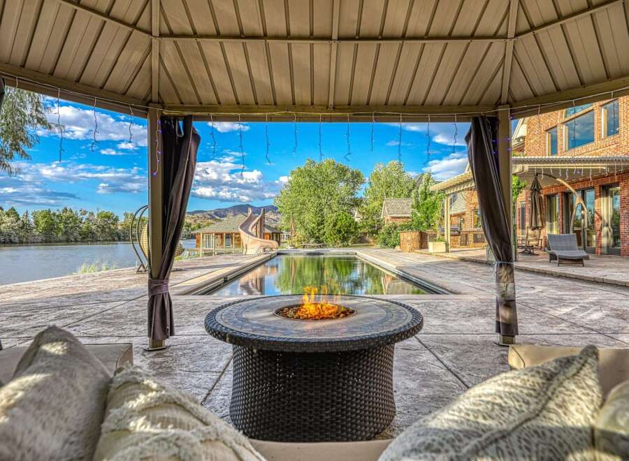 Experience luxury outdoor living with this stunning property featuring a sparkling swimming pool and a relaxing fire pit area, perfect for entertaining.