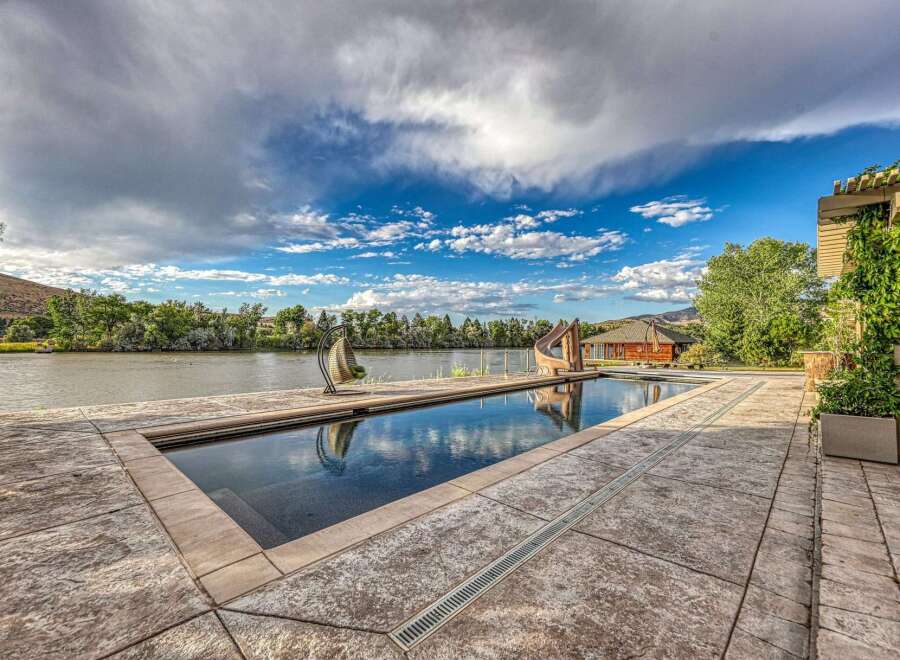 Experience luxury living with this stunning property featuring a pristine swimming pool and a scenic waterfront view.