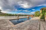 Experience luxury living with this stunning property featuring a pristine swimming pool and a scenic waterfront view.