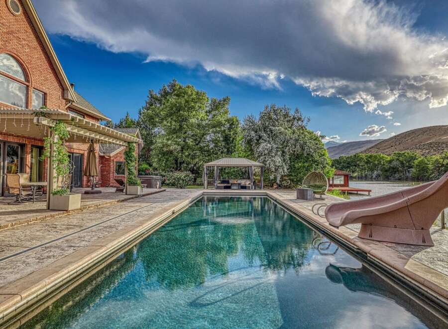 Experience luxury outdoor living with this stunning backyard oasis, featuring a sparkling swimming pool and a relaxing hot tub.