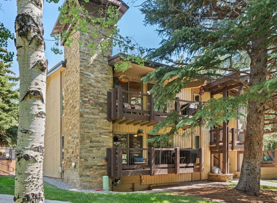 Experience mountain living in this charming property featuring a striking stone-clad chimney and multiple balconies perfect for enjoying the fresh air.