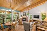 Experience rustic charm in this inviting living space featuring a vaulted wood-beamed ceiling and a cozy brick fireplace.