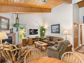 Cozy living room featuring a rustic stone fireplace, a comfortable sofa, and a unique log-style armchair.