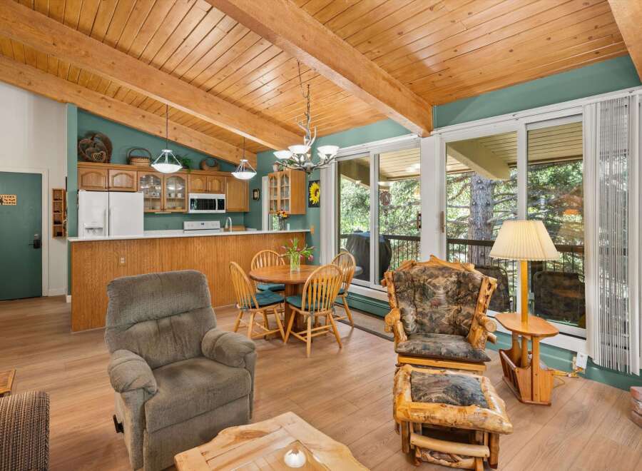 Experience rustic charm in this inviting living and dining area, featuring a cozy recliner and a unique log-style armchair with an ottoman.