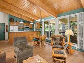 Experience rustic charm in this inviting living and dining area, featuring a cozy recliner and a unique log-style armchair with an ottoman.