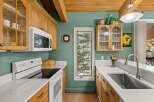 Discover this charming kitchen featuring warm oak cabinetry and elegant marble countertops.