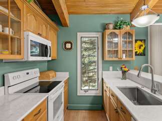 Discover this charming kitchen featuring warm oak cabinetry and elegant marble countertops.