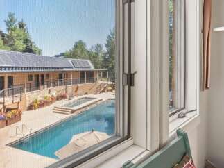 Experience luxury living with this stunning property featuring a sparkling swimming pool and an inviting hot tub, perfect for relaxation and entertainment.