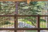 Enjoy the serene natural beauty from this balcony, overlooking a lush green landscape and a winding pathway.