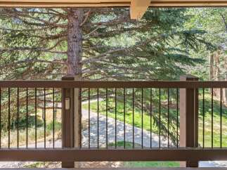 Enjoy the serene natural beauty from this balcony, overlooking a lush green landscape and a winding pathway.