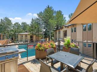 Enjoy outdoor living at its finest with this spacious balcony featuring a built-in grill and comfortable seating area.
