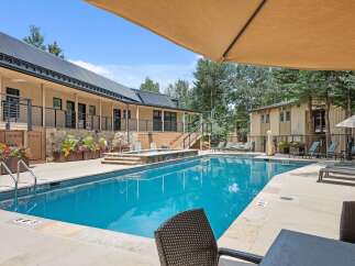 Enjoy a refreshing dip in this stunning swimming pool, complete with a relaxing hot tub and ample lounge seating.