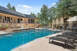 Enjoy a refreshing dip in the sparkling blue pool, surrounded by lush landscaping and comfortable lounge chairs.