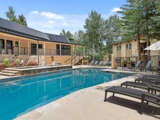 Enjoy a refreshing dip in the sparkling blue pool, surrounded by lush landscaping and comfortable lounge chairs.