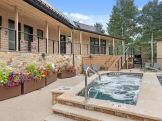Enjoy a relaxing soak in the bubbling hot tub, surrounded by vibrant flowers and modern architecture.