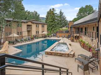 Enjoy a refreshing dip in the sparkling blue swimming pool or relax in the bubbling hot tub, surrounded by lush trees and mountain views.
