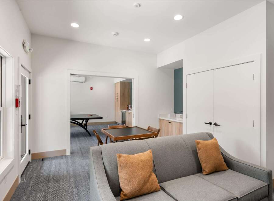 This inviting common area features a comfortable gray sofa with accent pillows, perfect for relaxation.