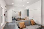 This inviting common area features a comfortable gray sofa with accent pillows, perfect for relaxation.