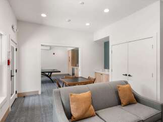 This inviting common area features a comfortable gray sofa with accent pillows, perfect for relaxation.